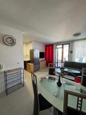 a kitchen and living room with a table and a couch at VP Palazzo Nesebar in Nesebar
