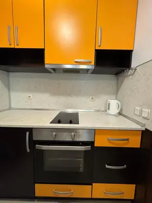 a kitchen with orange cabinets and a stove at VP Palazzo Nesebar in Nesebar