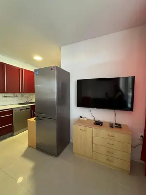 a kitchen with a large flat screen tv on the wall at VP Palazzo Nesebar in Nesebar