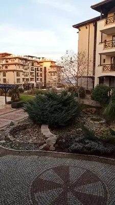 a garden in front of a building with christmas trees at Premium Oasis Beach Club Apartment in Lozenets