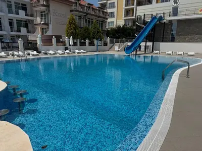a large swimming pool with a slide in a building at Luxury seaside apartment with seaview in Sveti Vlas