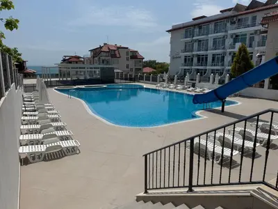 a large swimming pool with chairs and a slide at Luxury seaside apartment with seaview in Sveti Vlas