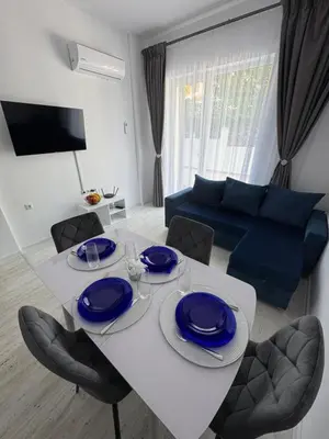 a living room with a white table with blue plates on it at Luxury seaside apartment with seaview in Sveti Vlas