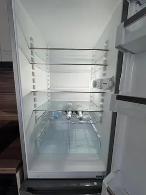 an empty refrigerator with its door open with a cat inside at Grand Villa luxury apartment with sea view in Sveti Vlas