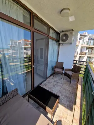 a balcony with a table and chairs on a building at Diamond beach apartment in Sveti Vlas