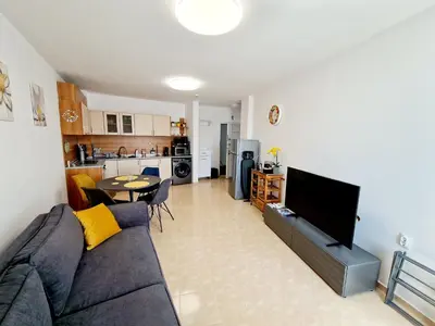 a living room with a couch and a tv and a kitchen at Lazur 2 beach apartment in Sveti Vlas