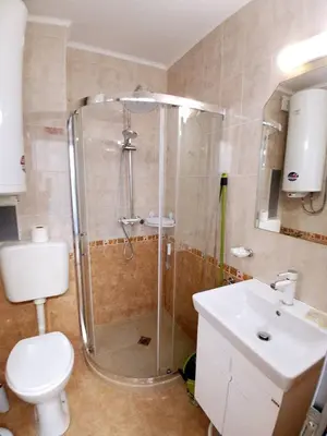 a bathroom with a shower and a toilet and a sink at Lazur 2 beach apartment in Sveti Vlas
