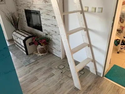 a wooden ladder in a living room with a television at Seaview Young Family - Семейство на Черно море in Aheloy