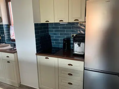 a kitchen with white cabinets and a stainless steel refrigerator at Seaview Young Family - Семейство на Черно море in Aheloy