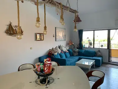 a living room with a blue couch and a table at Seaview Young Family - Семейство на Черно море in Aheloy