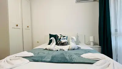 two white swans sitting on top of a bed at ASTORIA II Apartment 12 Sveti Vlas in Elenite