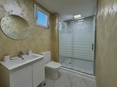 a bathroom with a shower and a toilet and a sink at Seagull Apartments in Byala