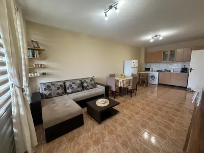 a living room with a couch and a table and a kitchen at Dream holiday Ravda in Ravda