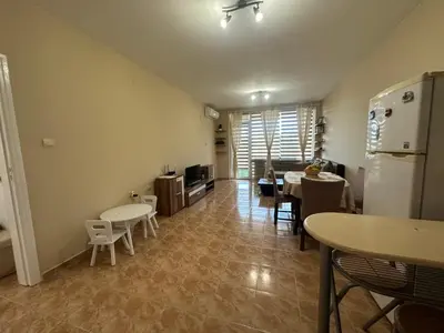 a kitchen and dining room with tables and a refrigerator at Dream holiday Ravda in Ravda