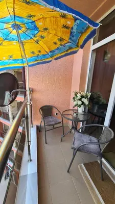 a patio with a table and chairs and an umbrella at Studio 67 & Apartment 16 Rainbow Holiday Complex in Sunny Beach