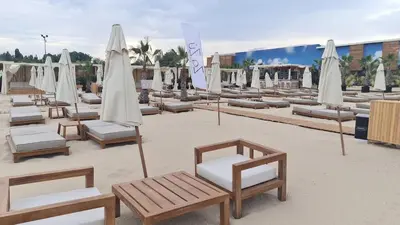 a group of lounge chairs and umbrellas on a beach at Studio 67 & Apartment 16 Rainbow Holiday Complex in Sunny Beach