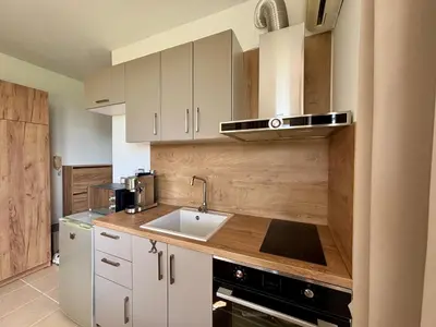 a kitchen with white cabinets and a sink at Sunset Deluxe in Kosharitsa