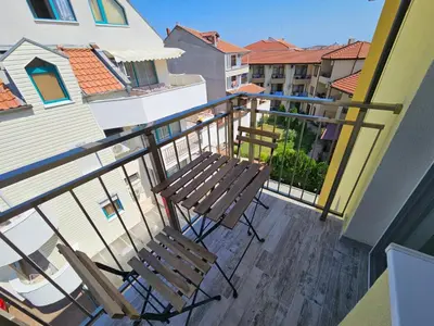 two wooden chairs sitting on a balcony with a balcony at Естрела къща за гости in Ravda