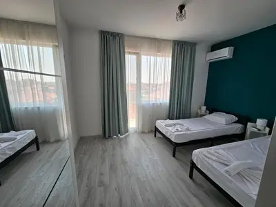 a room with two beds and a mirror at Естрела къща за гости in Ravda