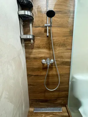 a shower with a hose attached to a wooden wall at The Master and Margarita Centre in Burgas City