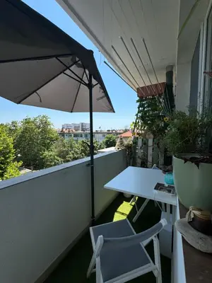 a balcony with an umbrella and a table and chairs at The Master and Margarita Centre in Burgas City