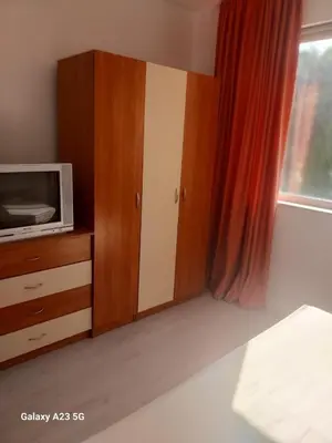 a room with a tv and a cabinet with a microwave at Апартамент Бяла in Byala