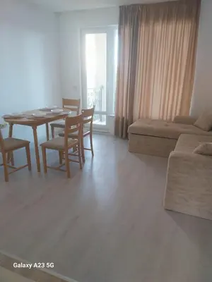 a living room with a table and chairs and a couch at Апартамент Бяла in Byala