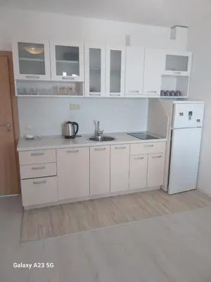 a white kitchen with a sink and a refrigerator at Апартамент Бяла in Byala