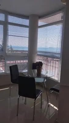 a dining room with a table and chairs and windows at Yana Privilege apartment Elinite in Elenite