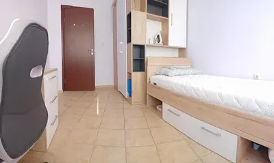 a small room with a bed and a closet at Akrotiri 2BR Apartment in Sozopol