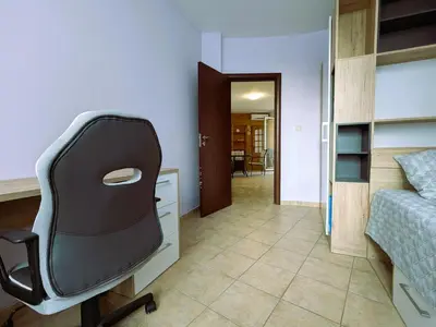 a bedroom with a desk and a chair next to a bed at Akrotiri 2BR Apartment in Sozopol