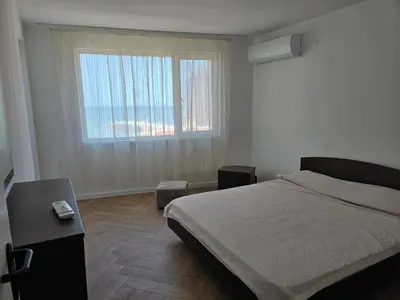 a bedroom with a bed and a large window at Izabela in Pomorie