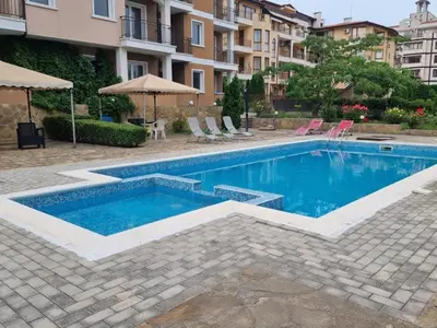 a swimming pool with blue water in a building at Studio Павлови Домус Екстра in Sveti Vlas