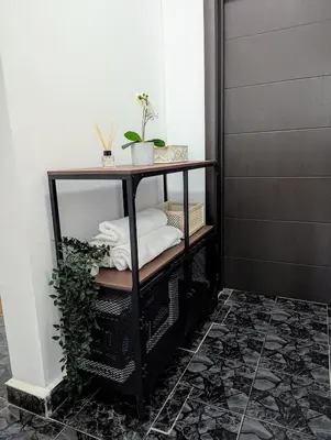 a black shelf with towels and plants on it at Apartment Dimanov 1 in Burgas City