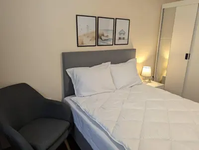 a bedroom with a bed and a chair in it at Apartment Dimanov 1 in Burgas City