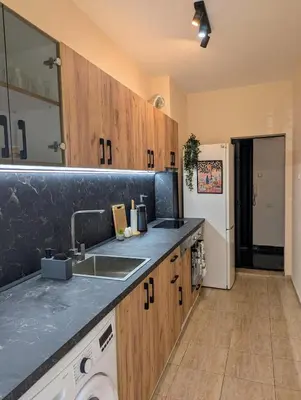 a kitchen with wooden cabinets and a sink and a refrigerator at Apartment Dimanov 1 in Burgas City