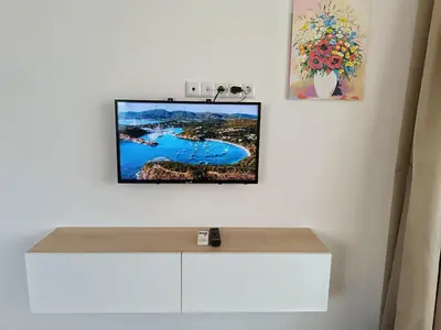 a flat screen tv hanging on a white wall at Апартамент 10 улица Македония 33 in Pomorie