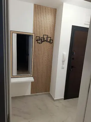 a hallway with a mirror and a brown door at Апартамент 10 улица Македония 33 in Pomorie