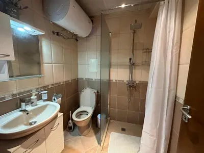 a bathroom with a toilet and a sink and a shower at Shishkova Garden Apartments in Varna City