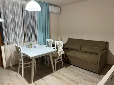 a living room with a table and a couch at Shishkova Garden Apartments in Varna City