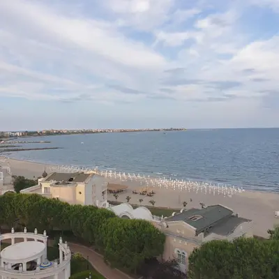 a view of a beach with a group of white umbrellas at Apartment Sunset resort C4-17 in Pomorie
