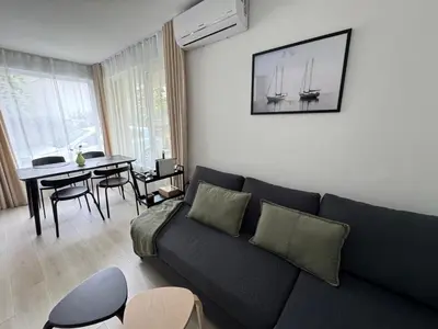 a living room with a couch and a dining table at Summer Apartment in Burgas City