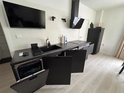 a kitchen with a sink and a tv on the wall at Summer Apartment in Burgas City