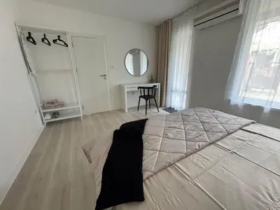 a bedroom with a large bed and a table at Summer Apartment in Burgas City