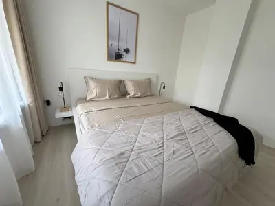 a white bedroom with a large bed in it at Summer Apartment in Burgas City