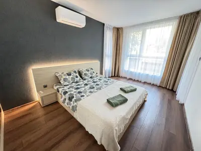 a bedroom with a bed and a large window at Infinity Apartament in Burgas City