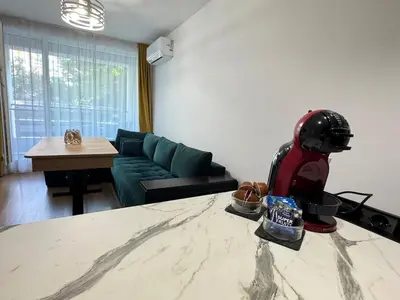 a living room with a couch and a helmet on a table at Infinity Apartament in Burgas City