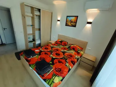 a bedroom with a bed with red flowers on it at Апартамент 11 улица Македония 33 Поморие in Pomorie