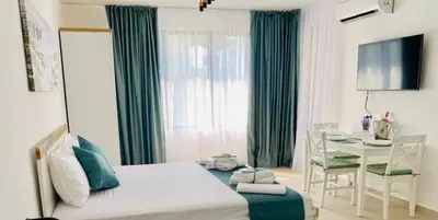 a bedroom with a table and a bed and a table and chairs at BAMBOO BEACH STUDIO- Sozopol in Sozopol