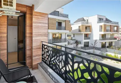 a balcony with a chair and some buildings at BAMBOO BEACH STUDIO- Sozopol in Sozopol